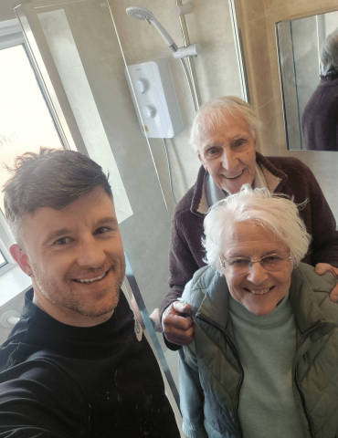 owner lance cooksey with two elderly homeowners in a new renovated bathroom in rhoose, south wales.