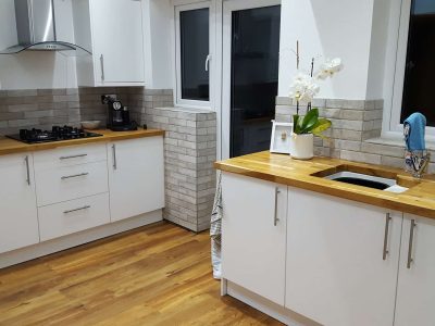 Services 18 new kitchen with white units, wood worktops and tiled splashback