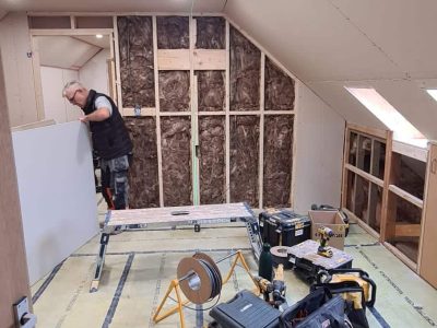 Services 15 loft conversion in progress with exposed framing and built-in storage